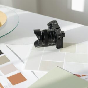 Digital camera resting on a desk with color swatches and design materials.